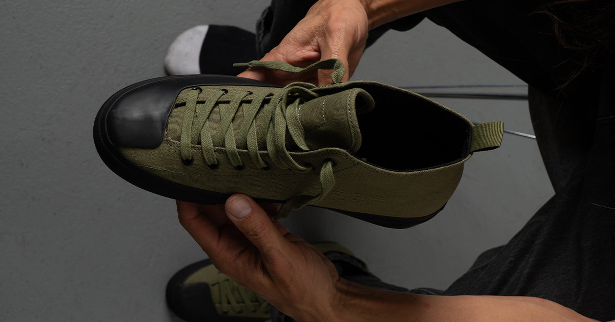 Kenny Anderson holding his signature skate shoe